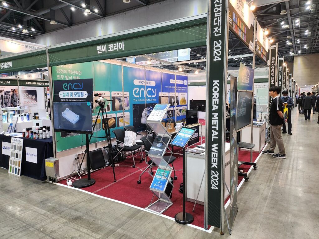 A trade booth at Korea Metal Week features various displays and equipment.