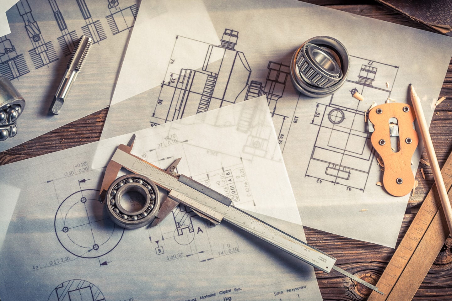 Technical drawings and tools are arranged on a work surface.