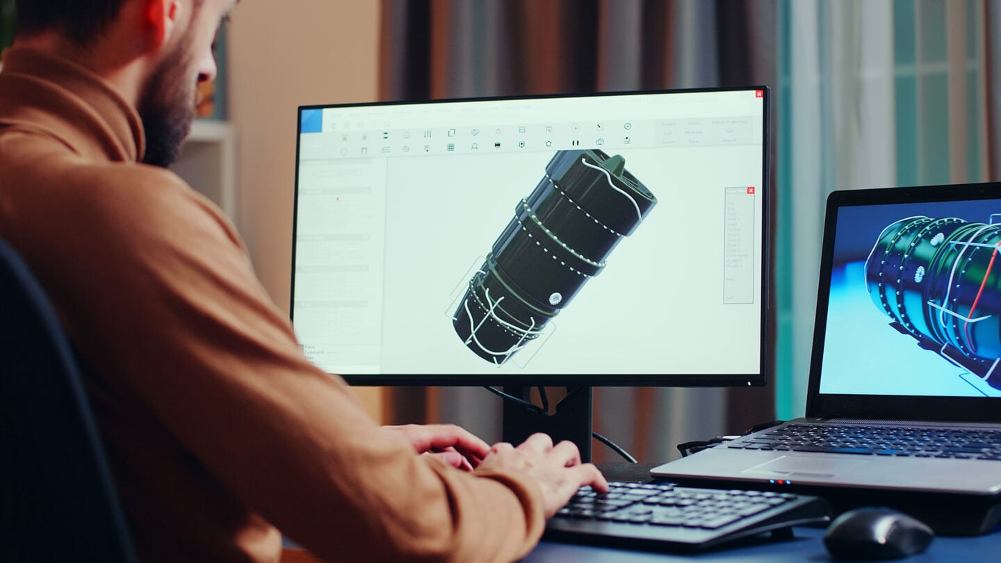 A young engineer works on a 3D design using computer software.