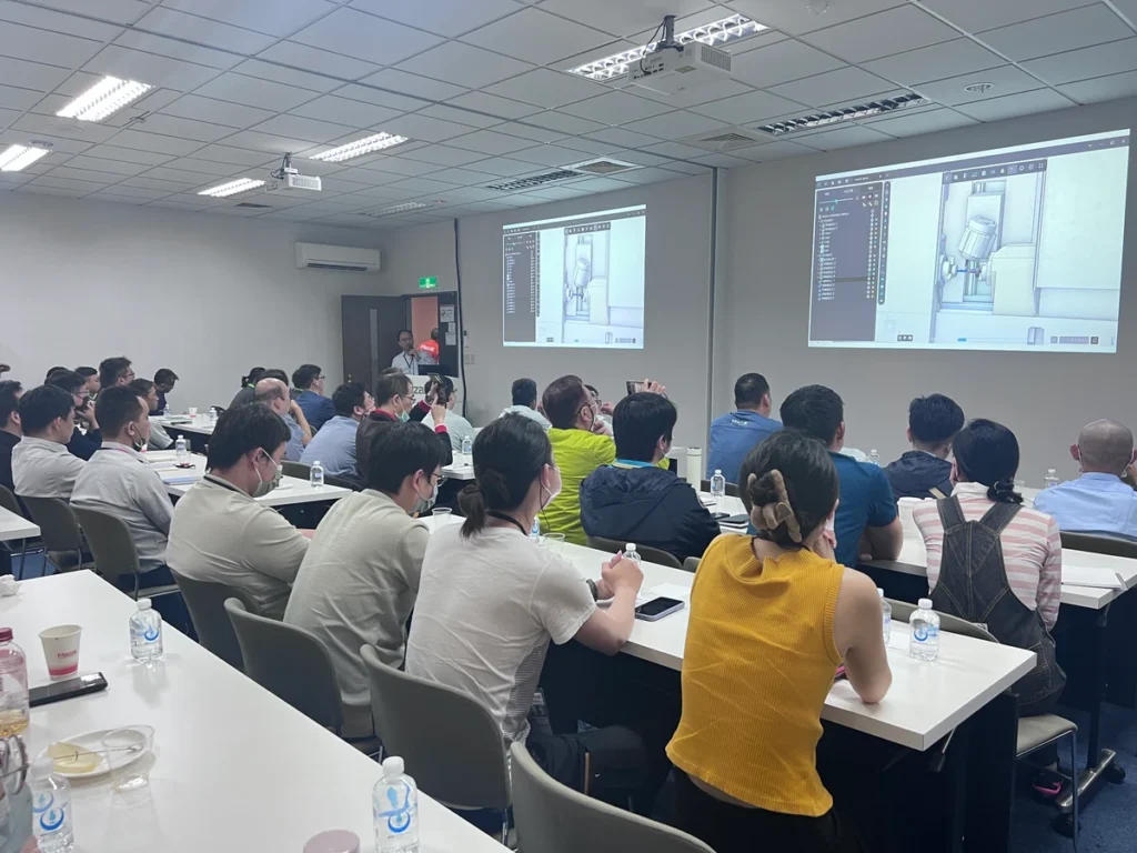 A group of people attentively listening to a presentation in a classroom setting.