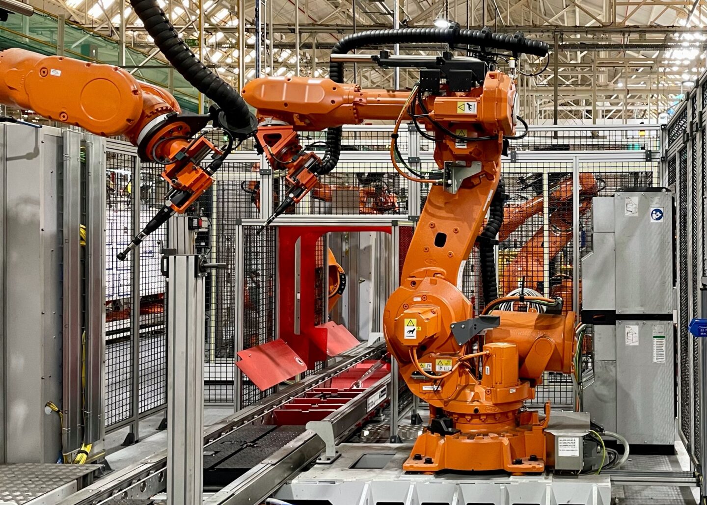 Industrial robots operate in a manufacturing setting, showcasing automation.