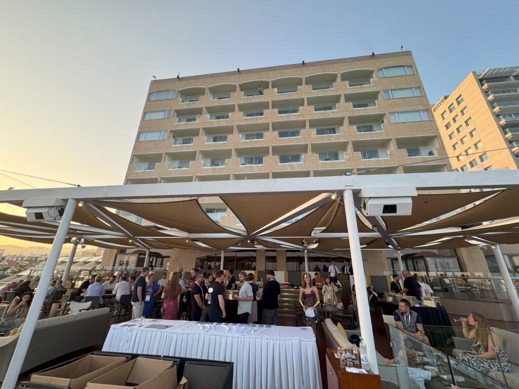 A lively outdoor gathering takes place at a beachfront venue.
