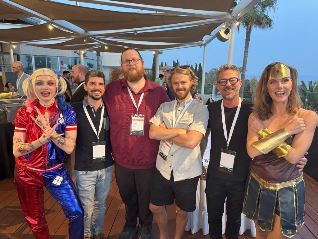 A group of six people poses together at an outdoor event.