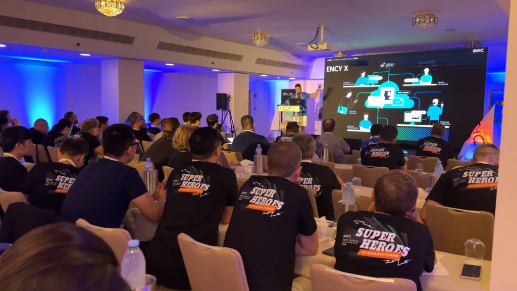 A conference audience listens to a presentation on technology.