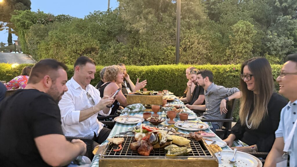 A group of friends enjoys a summer barbecue dinner outdoors.