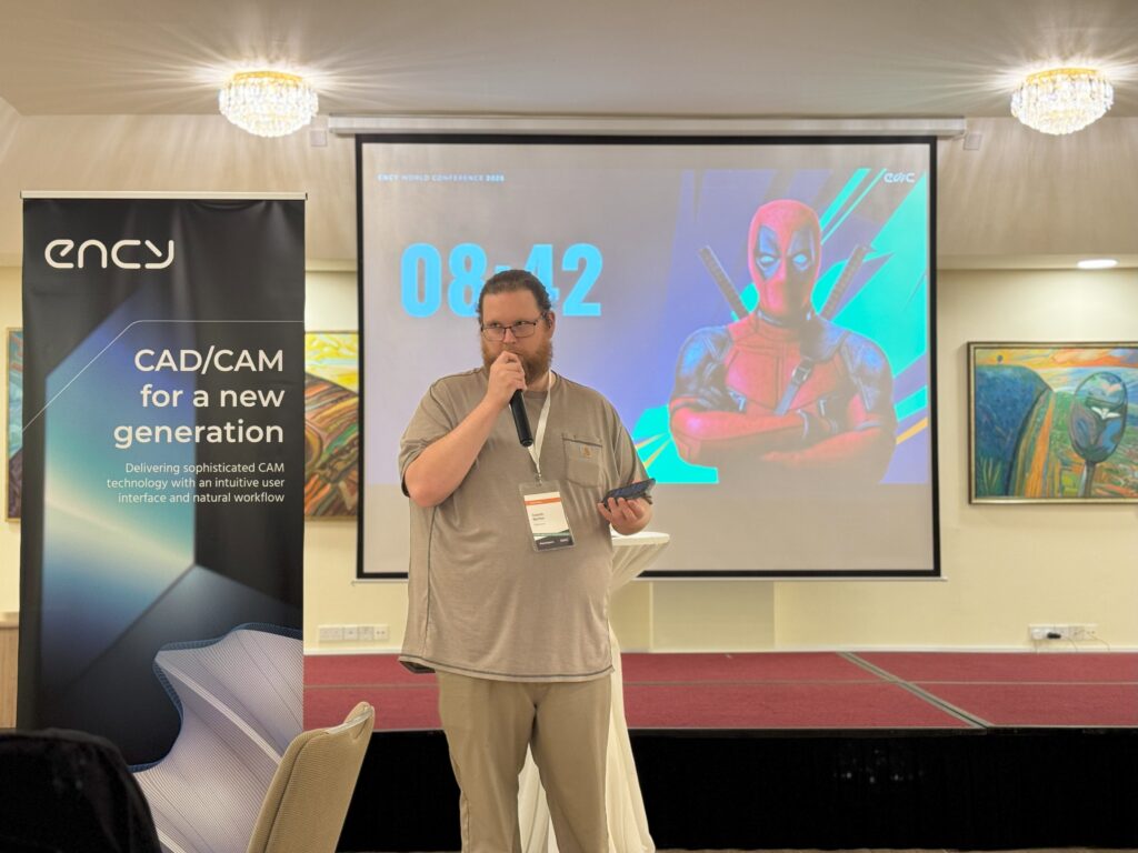 A speaker presents at a conference with a colorful backdrop.