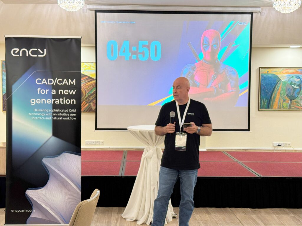 A speaker presents on stage with a timer and visuals in the background.