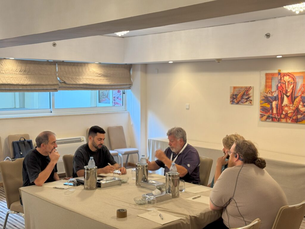 A group of five people engaged in discussion around a table.