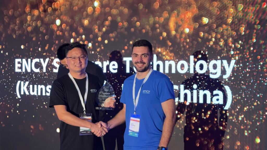 Two men shake hands while celebrating a technology award achievement.
