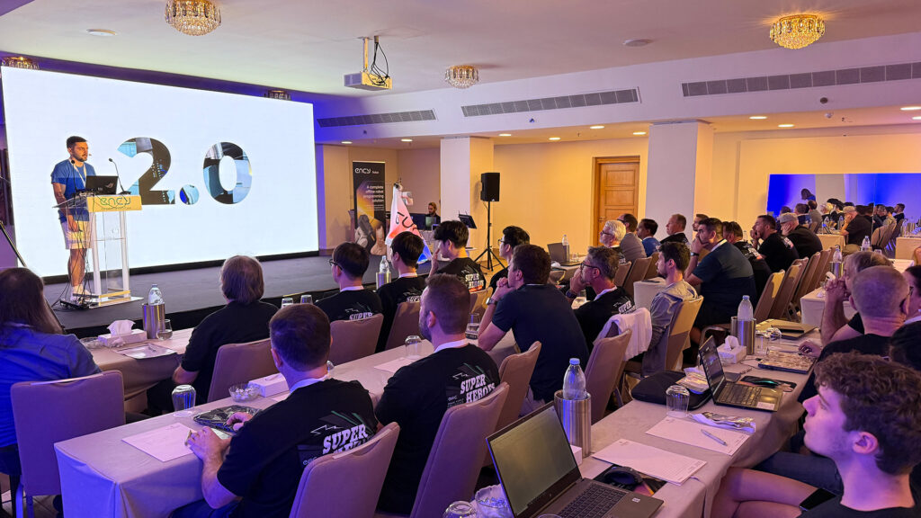 A presentation on a screen is being attended by an audience.