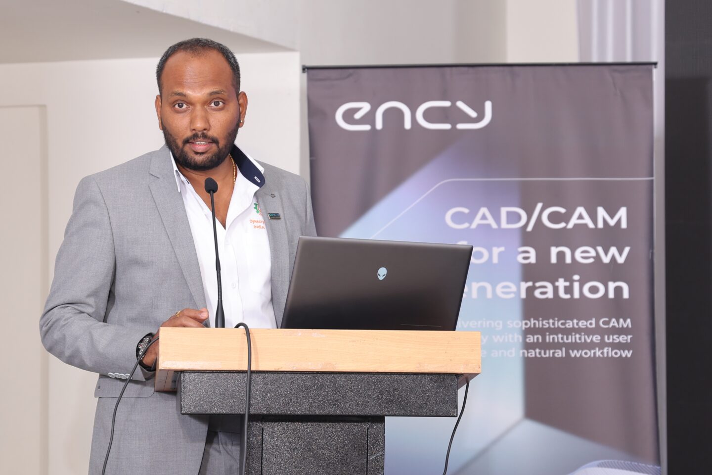 A man presents information on CAD/CAM technology at a conference.