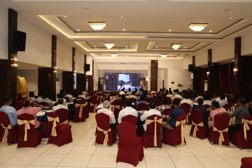 A conference hall with attendees seated and facing a stage.