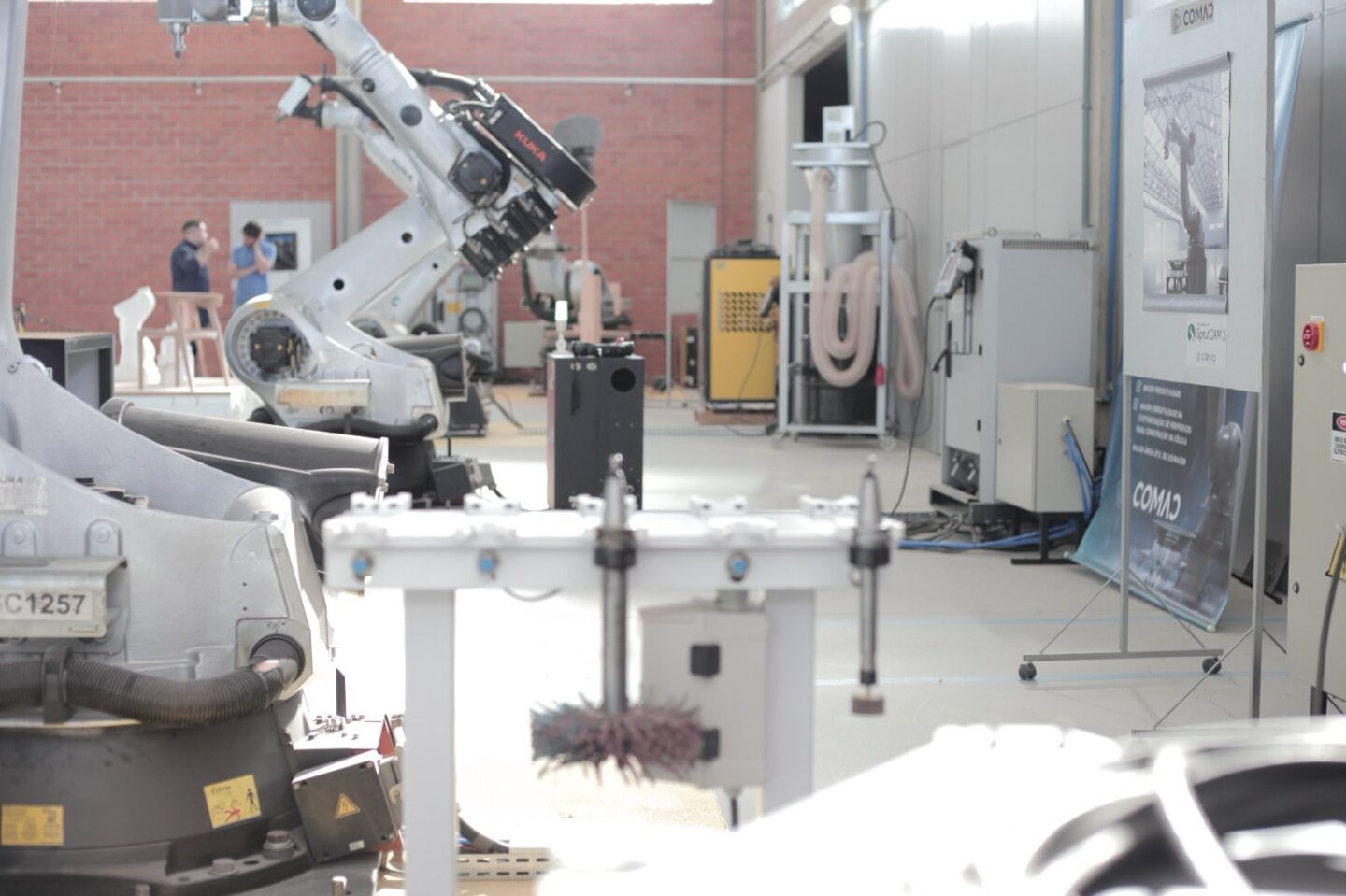 A robotic arm operates in a workshop filled with machinery.