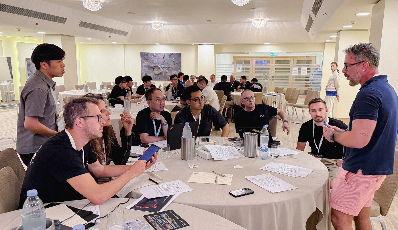 Participants engage in discussion around a table on Day 3 of the event.