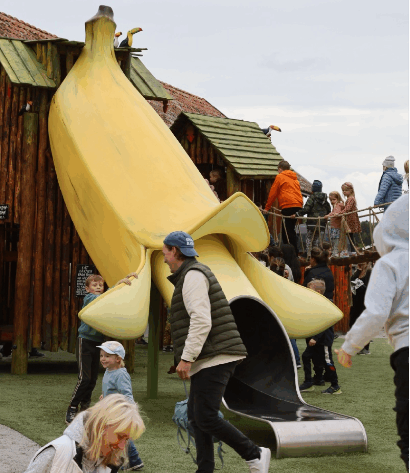 A large yellow banana slide entertains children at a playground.
