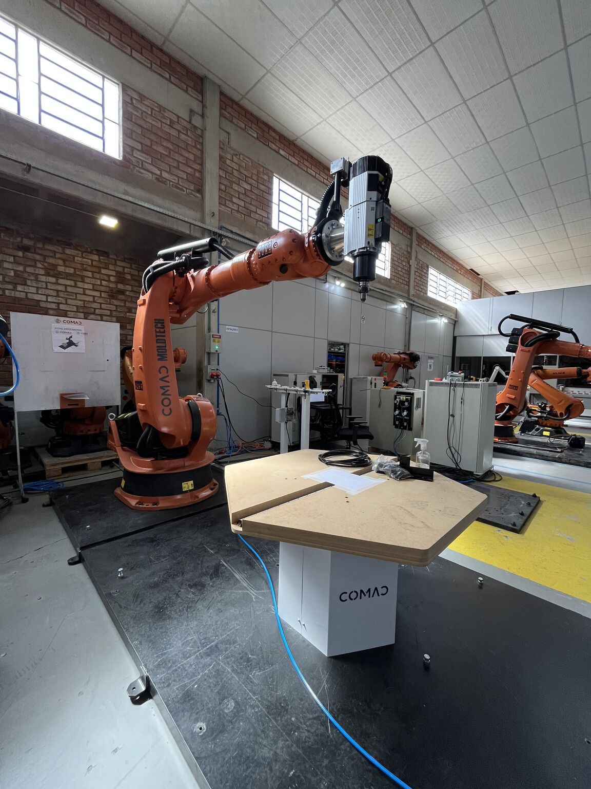 Six-axis collaborative robot arm performing automated welding on steel assembly with sparks flying