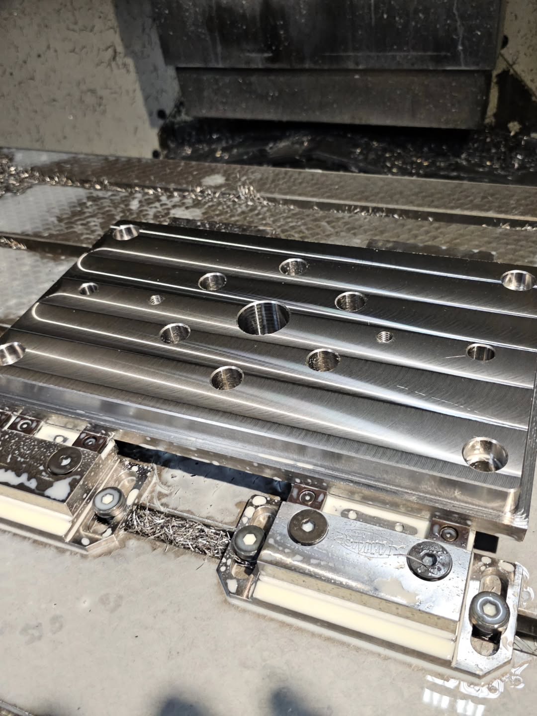 Rectangular aluminum plate with precision-milled slots in a CNC milling center