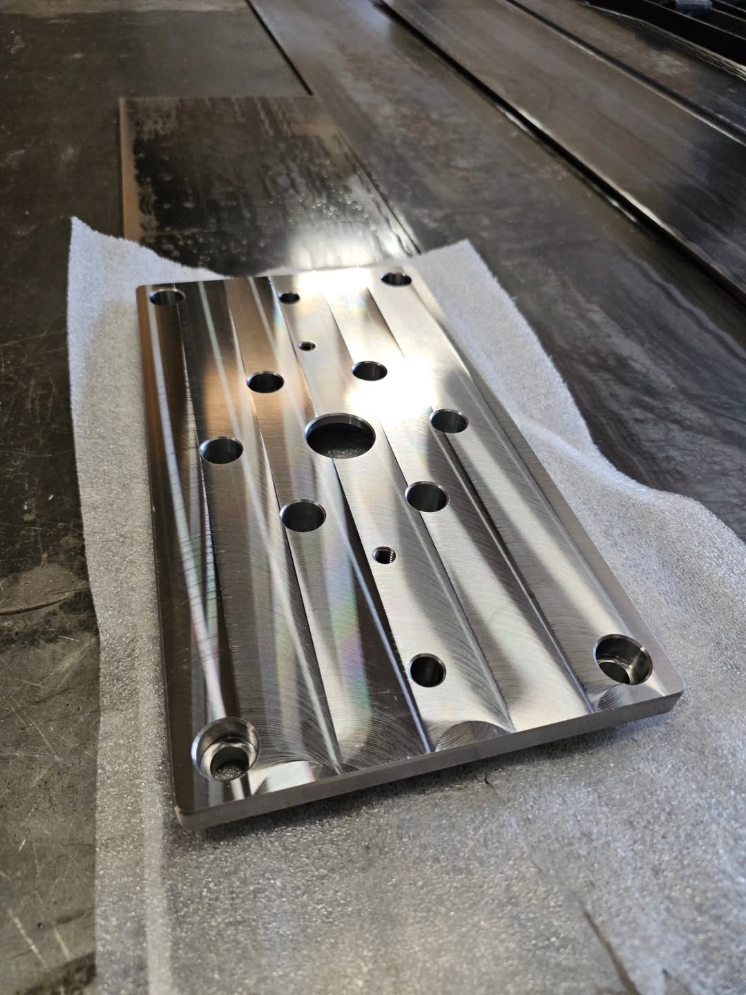 Flat aluminum tooling plate with drilled holes and milled pockets from CNC machining