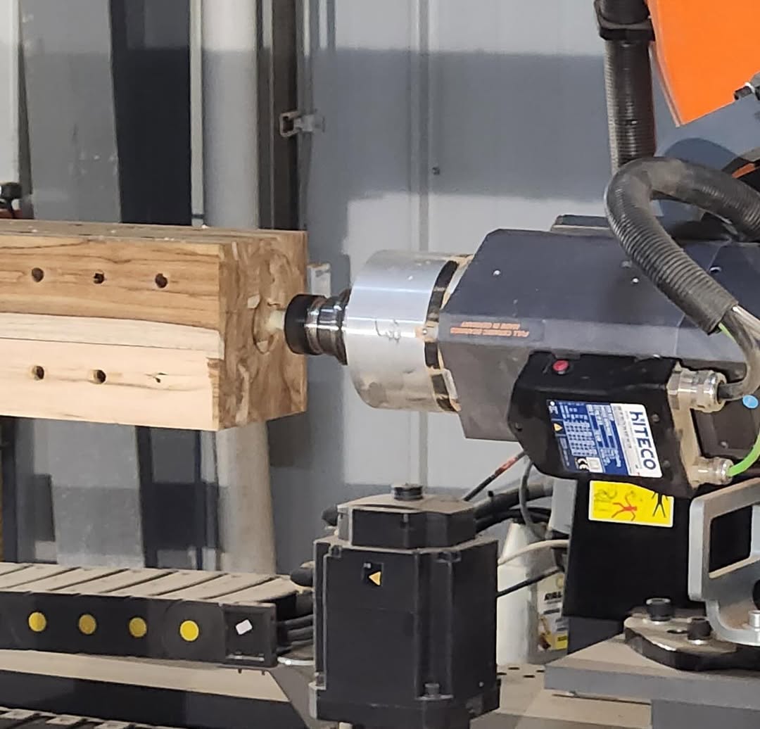 Hiteco-branded CNC spindle milling a wooden beam with evenly spaced holes