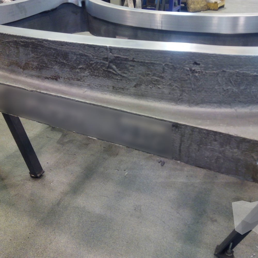 Large circular metal ring with a turned inner bore and rough outer face on a worktable, produced by CNC lathe