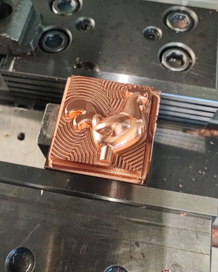 Copper block CNC-milled into a detailed horse or unicorn head relief with visible toolpaths