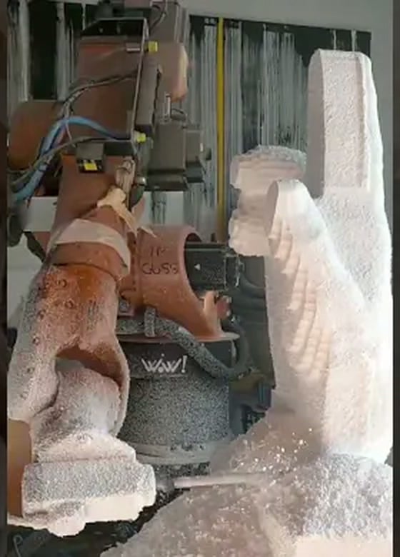 KUKA robot milling a large polystyrene block into a hand sculpture