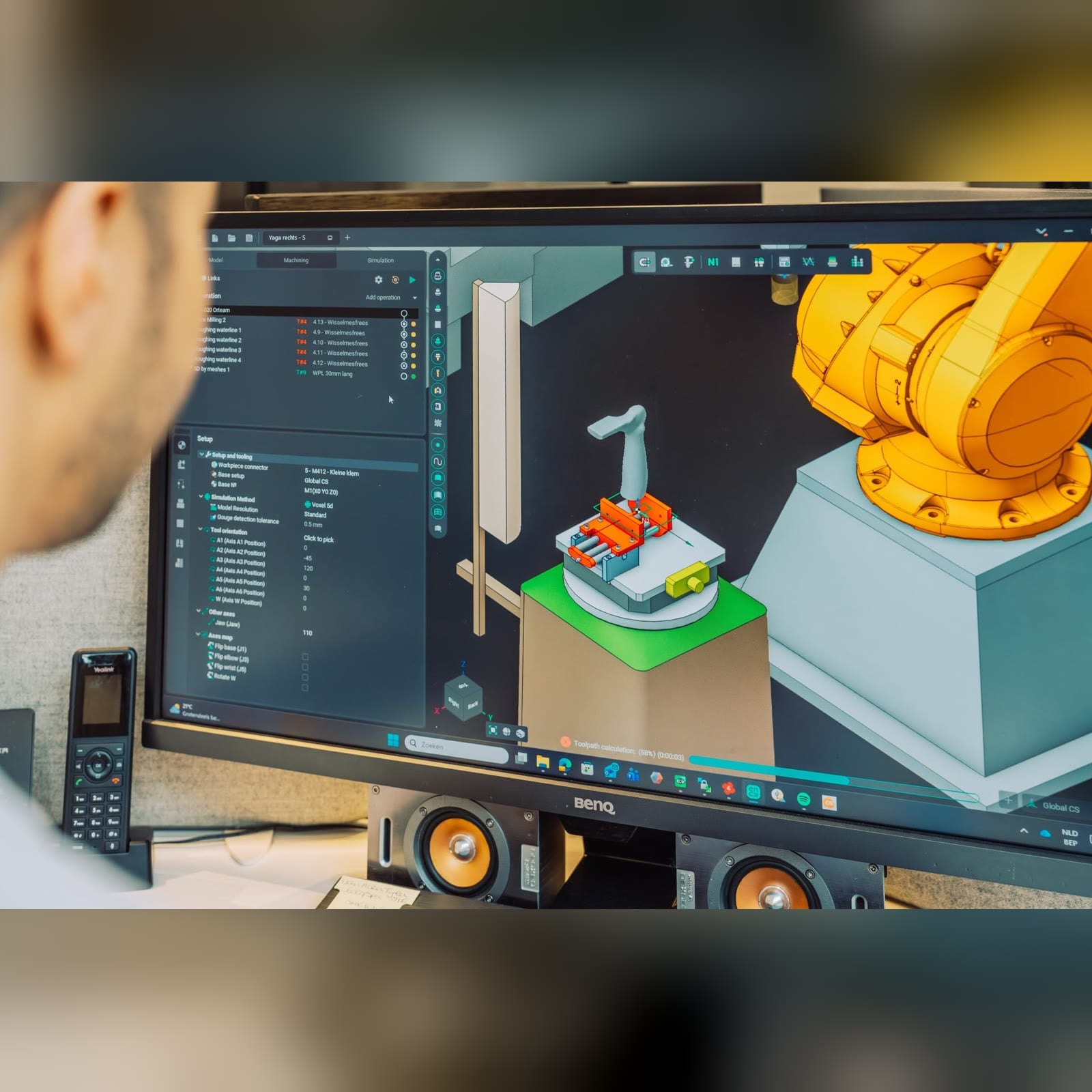 Monitor showing a robotic cell simulation with a yellow robot