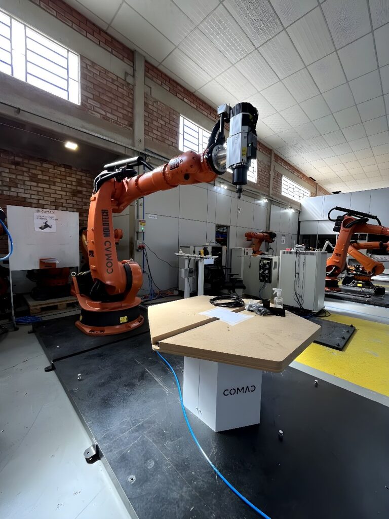 Six-axis collaborative robot performing automated welding on a steel assembly with sparks
