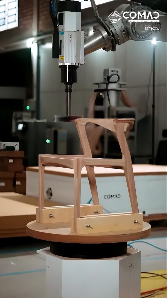 Six-axis robotic arm CNC-milling the curved back and seat support of a wooden chair frame on a rotating worktable