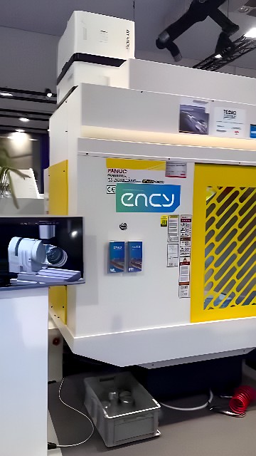 FANUC Robodrill CNC milling machine cutting a cylindrical metal component with finished parts in a bin below
