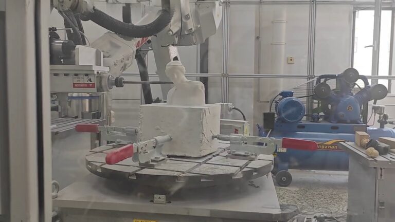 ABB six-axis industrial robot performing milling on a white block in an industrial setting