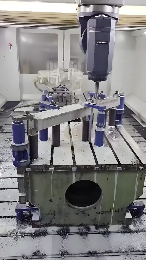 Vertical CNC milling center end-milling a metal housing blank with rotating cutter and custom fixture