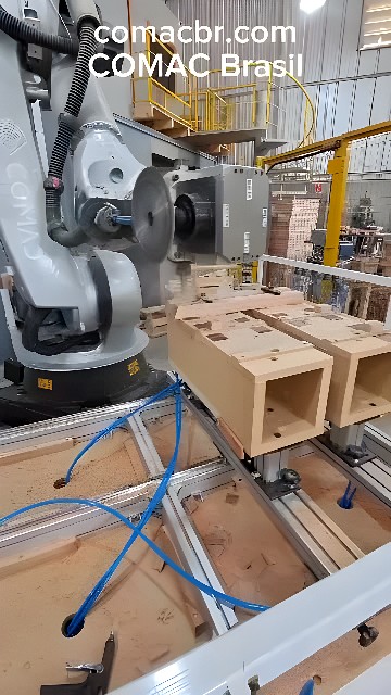Six-axis industrial robot with milling head machining wooden blocks in an automated woodworking line
