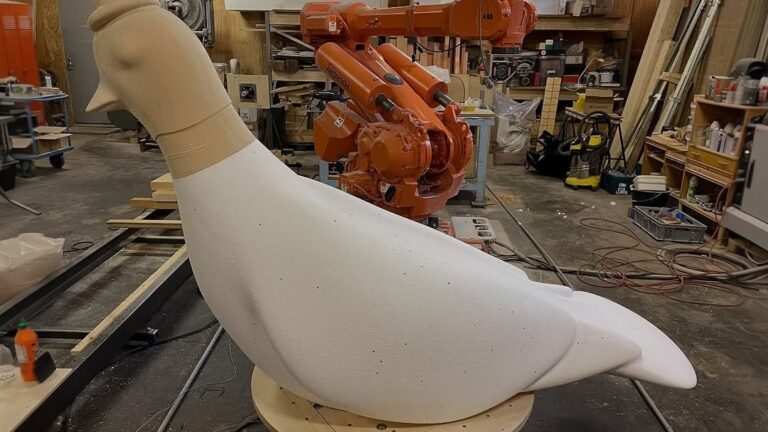 A foam mold being machined by an industrial robot in a workshop