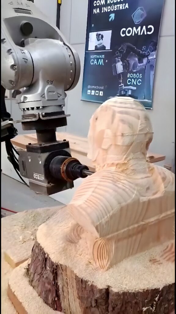 Six-axis industrial robot CNC milling a human bust from a cylindrical wood log