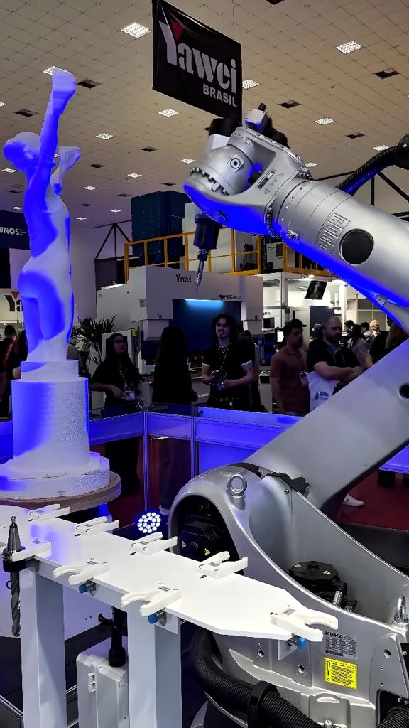 KUKA industrial robot arm milling a white foam human figure on a rotary table